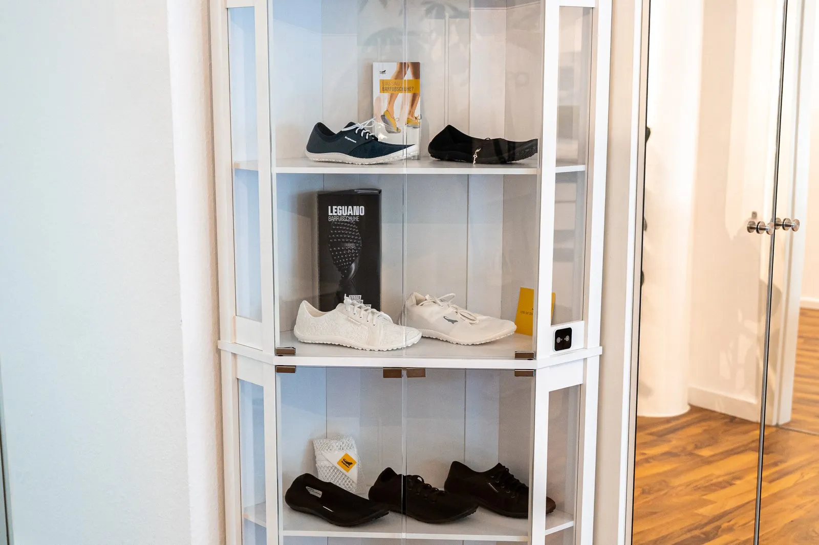 Vitrine mit Leguano-Barfußschuhen in der Praxis RS Physiotherapie Mettmann